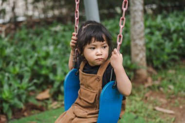 Neşeli küçük kız salıncakta oynuyor