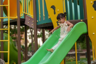 Mutlu bebek kız kayıyor ve dışarıda oyun oynuyor.