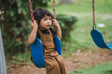Neşeli küçük kız salıncakta oynuyor