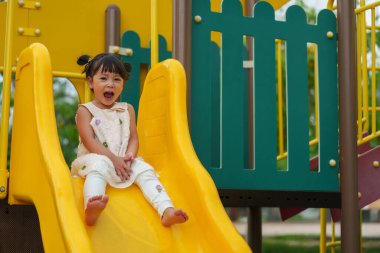 Mutlu bebek kız kayıyor ve dışarıda oyun oynuyor.