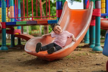 Mutlu bebek kız kayıyor ve dışarıda oyun oynuyor.