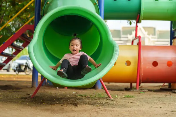 Mutlu bebek kız kayıyor ve dışarıda oyun oynuyor.