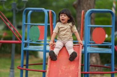 Mutlu bebek kız kayıyor ve dışarıda oyun oynuyor.