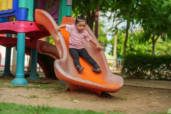 Mutlu bebek kız kayıyor ve dışarıda oyun oynuyor.