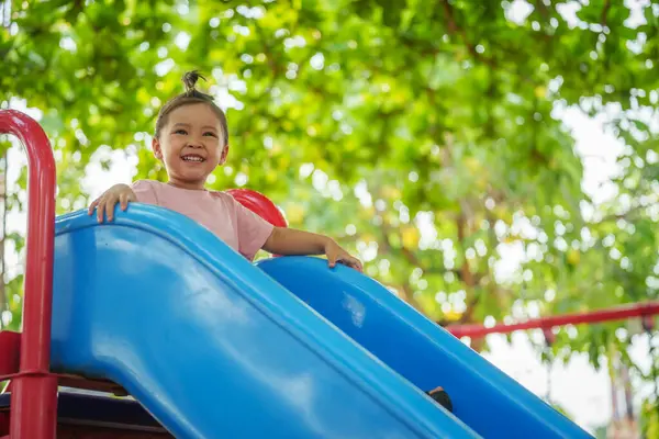 Mutlu bebek kız kayıyor ve dışarıda oyun oynuyor.