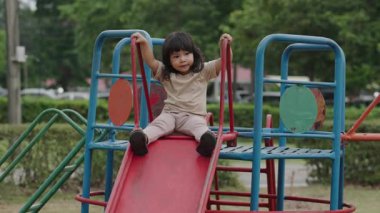 Küçük kız çocuk oyun parkında kayıyor