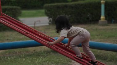 Küçük kız çocuk oyun parkında kayıyor