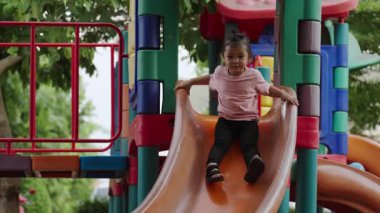 Mutlu bebek kız kayıyor ve dışarıda oyun oynuyor.