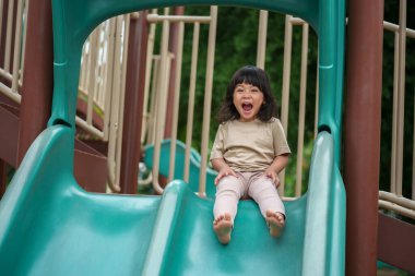 Mutlu bebek kız kayıyor ve dışarıda oyun oynuyor.