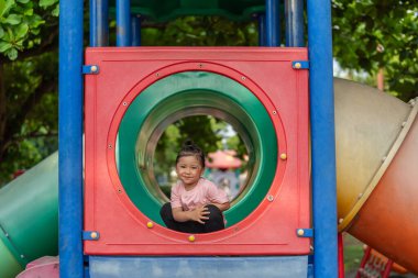 Parktaki çocuk parkında oynayan küçük mutlu kız.
