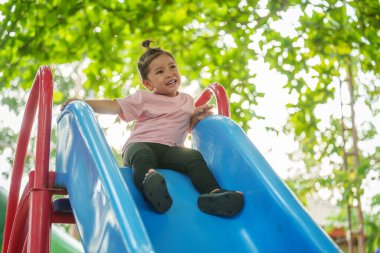 Mutlu bebek kız kayıyor ve dışarıda oyun oynuyor.