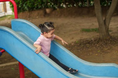 Mutlu bebek kız kayıyor ve dışarıda oyun oynuyor.