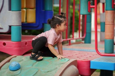 Parktaki çocuk parkında oynayan küçük mutlu kız.