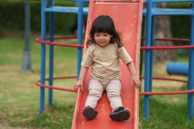 Mutlu bebek kız kayıyor ve dışarıda oyun oynuyor.
