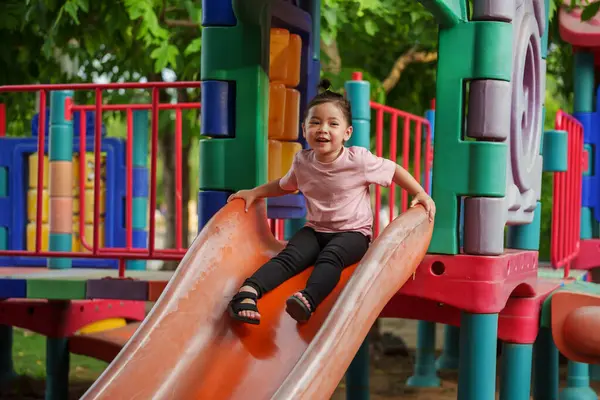 Mutlu bebek kız kayıyor ve dışarıda oyun oynuyor.