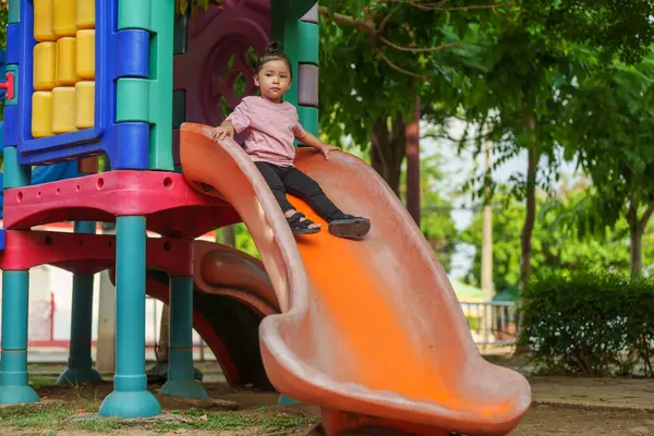 Mutlu bebek kız kayıyor ve dışarıda oyun oynuyor.