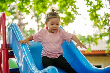 Mutlu bebek kız kayıyor ve dışarıda oyun oynuyor.