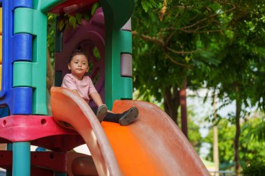 Mutlu bebek kız kayıyor ve dışarıda oyun oynuyor.
