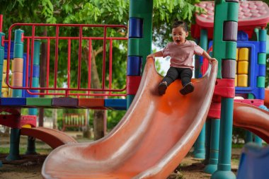 Mutlu bebek kız kayıyor ve dışarıda oyun oynuyor.