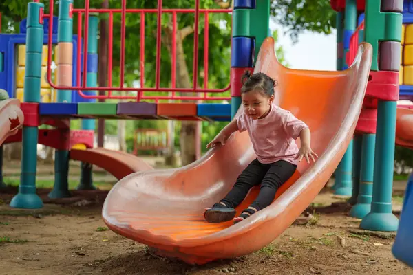 Mutlu bebek kız kayıyor ve dışarıda oyun oynuyor.