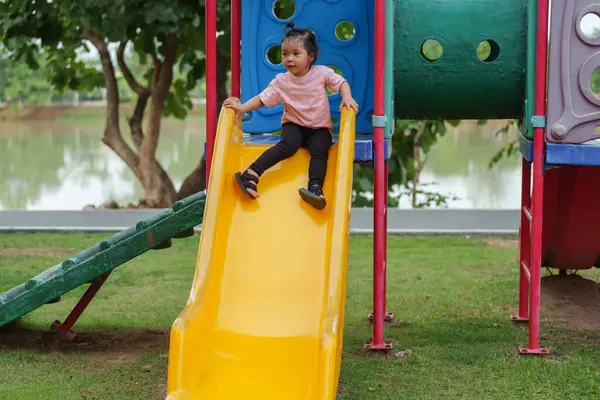 Mutlu bebek kız kayıyor ve dışarıda oyun oynuyor.