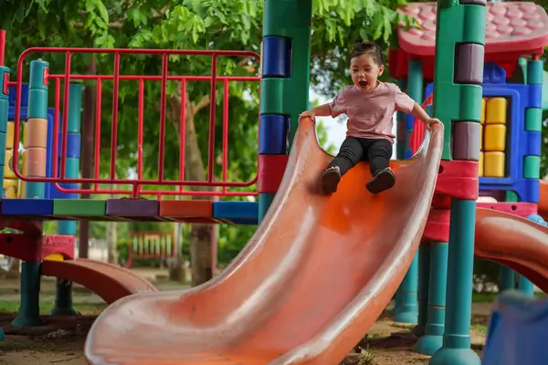 Mutlu bebek kız kayıyor ve dışarıda oyun oynuyor.
