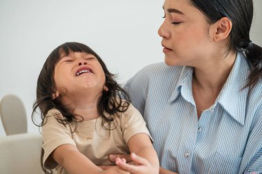 Anne ağlayan bebeğini teselli ediyor.