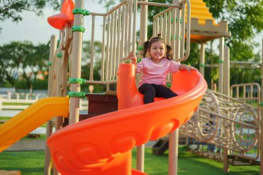 Mutlu bebek kız kayıyor ve dışarıda oyun oynuyor.