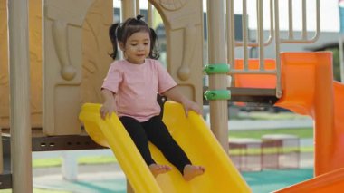 Yavru bebeğin açık havada kayıp oynaması ağır çekimde.