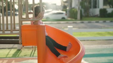 Yavru bebeğin açık havada kayıp oynaması ağır çekimde.