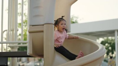 Yavru bebeğin açık havada kayıp oynaması ağır çekimde.