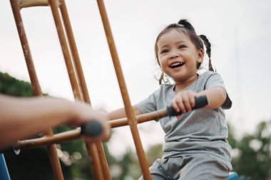 Neşeli küçük kız dışarıda Freind 'le çifte salıncakta oynuyor.