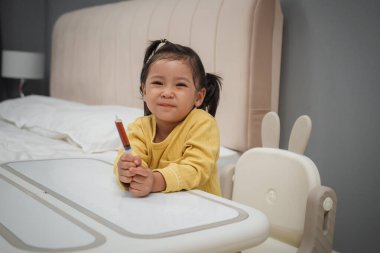 Mutlu küçük kız elinde şırıngayla şurup ilacı tutuyor.