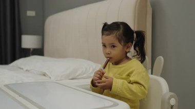 Küçük kız şırıngayla şurup ilacını tek başına alıyor. hasta çocuk