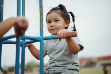 Neşeli küçük kız dışarıda Freind 'le çifte salıncakta oynuyor.