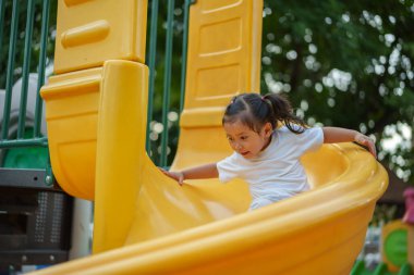 # Mutlu bebek kız bebek parkta kayıyor ve oynuyor #