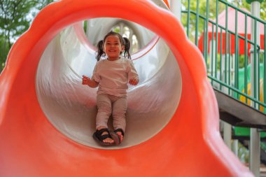 # Mutlu bebek kız bebek parkta kayıyor ve oynuyor #