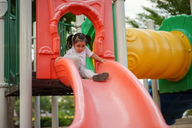 # Mutlu bebek kız bebek parkta kayıyor ve oynuyor #