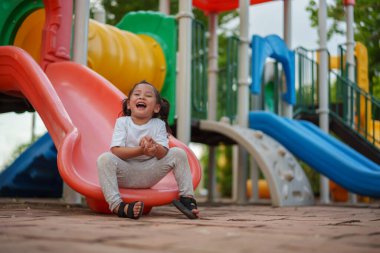 # Mutlu bebek kız bebek parkta kayıyor ve oynuyor #