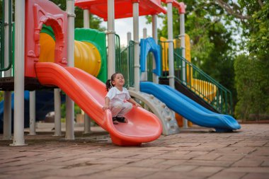 # Mutlu bebek kız bebek parkta kayıyor ve oynuyor #