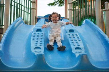 # Mutlu bebek kız bebek parkta kayıyor ve oynuyor #