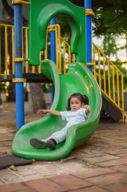 # Mutlu bebek kız bebek parkta kayıyor ve oynuyor #