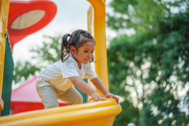 # Mutlu bebek kız bebek parkta kayıyor ve oynuyor #