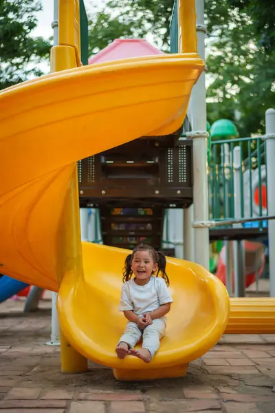 # Mutlu bebek kız bebek parkta kayıyor ve oynuyor #