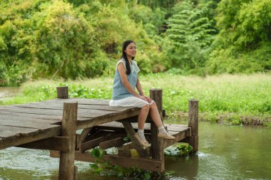 ahşap iskelesi kenarında oturan kadın