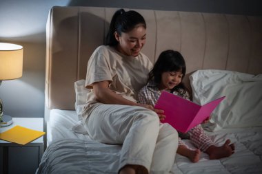 Anne, kitaptaki küçük kız için geceleri yatakta masal okurdu.