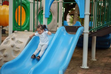 # Mutlu bebek kız bebek parkta kayıyor ve oynuyor #