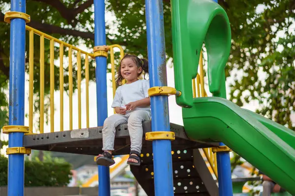 Parktaki çocuk parkında oynayan küçük mutlu kız.
