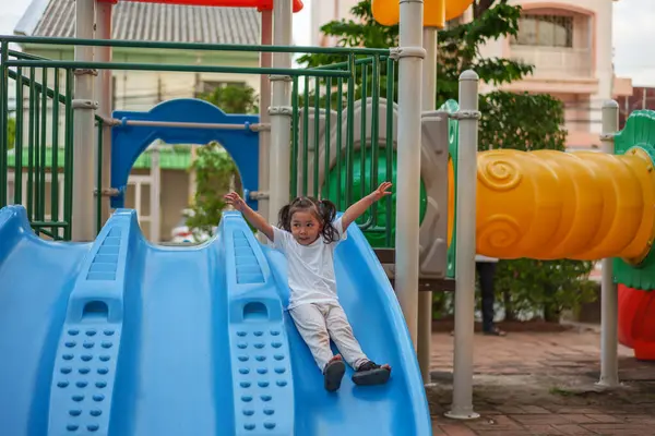 # Mutlu bebek kız bebek parkta kayıyor ve oynuyor #