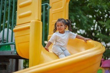 # Mutlu bebek kız bebek parkta kayıyor ve oynuyor #